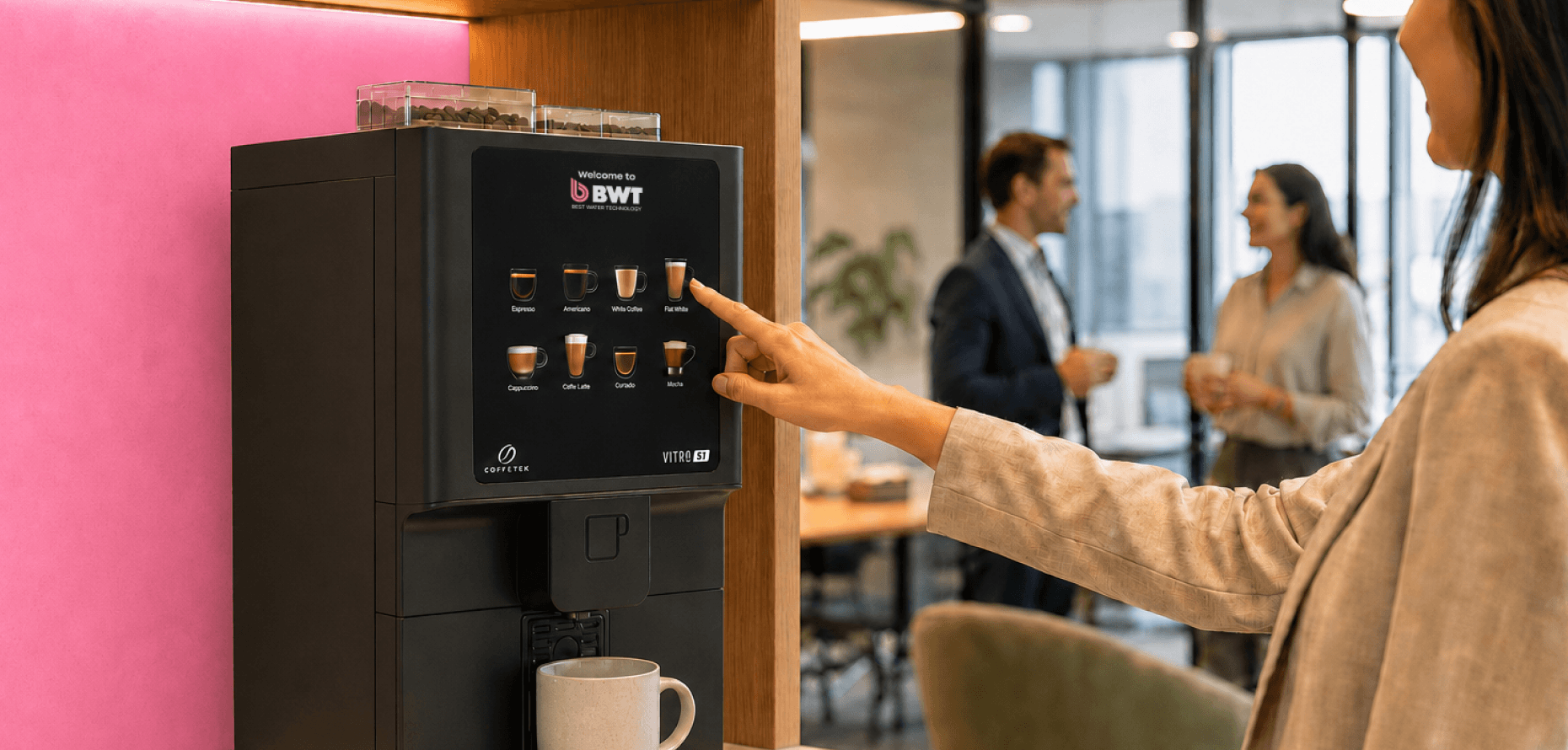 A person selecting a drink on a BWT bean-to-cup coffee machine in an office
